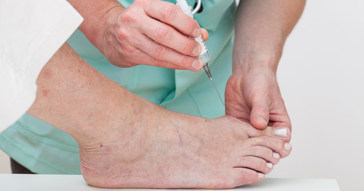Patient receiving foot injection from doctor