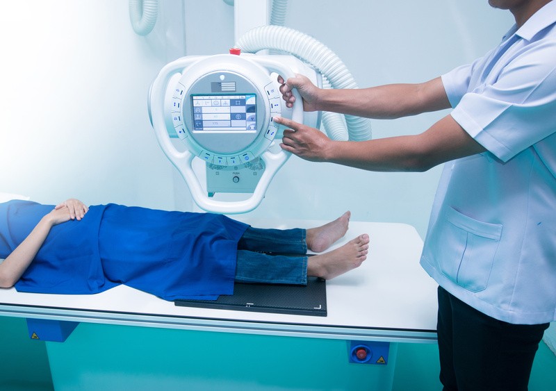 patient lying down under digital radiography machine